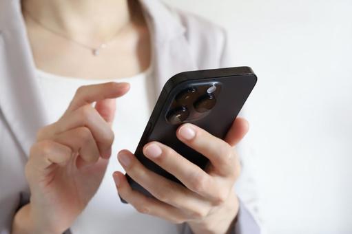 スマートフォンを使うビジネスウーマン スマートフォンを使うビジネスウーマン ビジネスウーマン,女性,連絡の写真素材