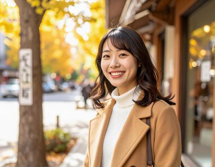 秋の街を歩く笑顔の女性 秋の街を歩く笑顔の女性の写真