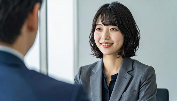 笑顔で話すスーツ姿の女性の写真