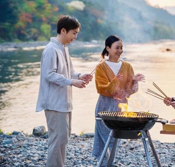 バーベキューを楽しむ男女 バーベキューを楽しむ男女の写真