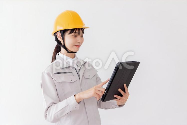 タブレットを使用する作業服の女性 女性,人物,日本人の写真素材