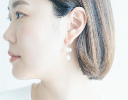 パールのイヤリングをつけた女性 パールのイヤリングをつけた女性の写真