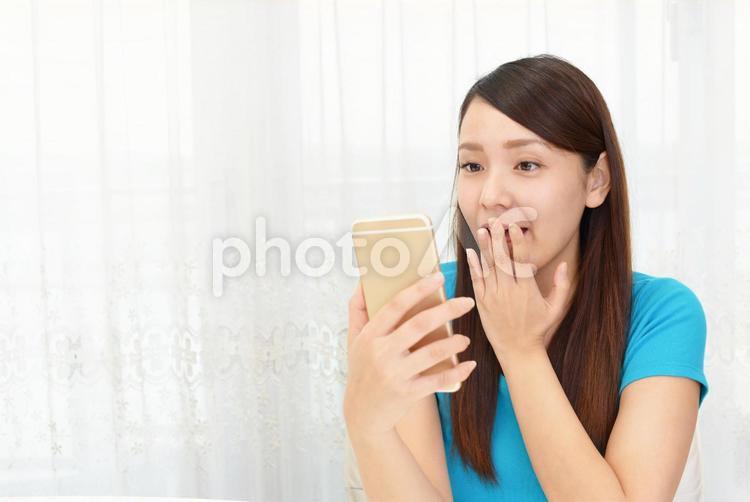 スマートフォンを持つ笑顔の女性 女性,スマートフォン,女の写真素材