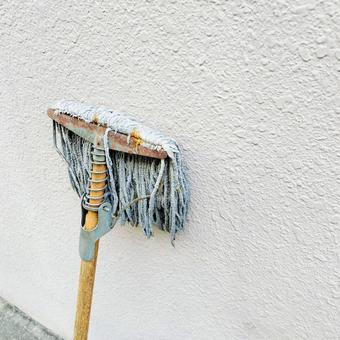 壁に立てかけられたモップ 壁に立てかけられたモップの写真