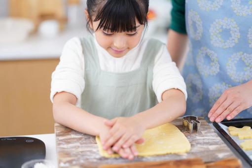 クッキー型で生地を抜くエプロン姿の女の子 女の子,日本人,型抜きの写真素材