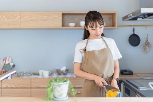 キッチンで料理をする笑顔の女性 キッチンで料理をする笑顔の女性の写真