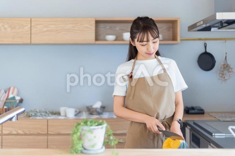 キッチンで料理をする笑顔の女性 女性,キッチン,料理の写真素材