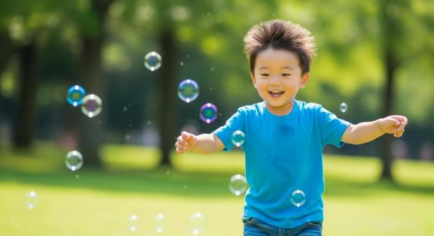 シャボン玉で遊ぶ笑顔の男の子 シャボン玉で遊ぶ笑顔の男の子の写真