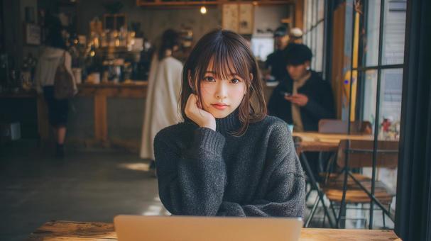 カフェでノートパソコンを使用する女性の写真