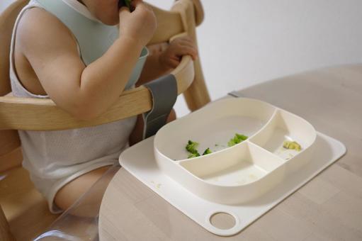 子どもが手づかみで野菜を口に運ぶ様子 子ども,赤ちゃん,手づかみの写真素材