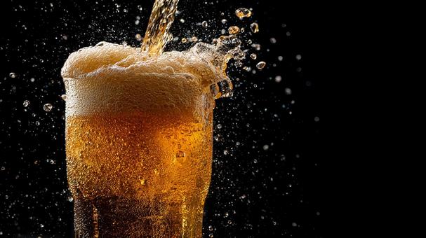 黄金のビール、泡が溢れる瞬間 黄金のビール、泡が溢れる瞬間の写真