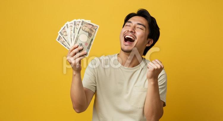 大金を手にして喜ぶ男性 お金,大金,お札の写真素材