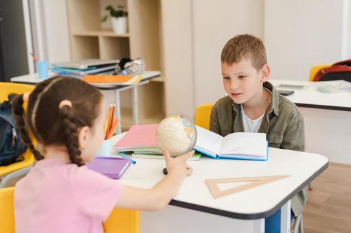 地球儀を持って振り向く女の子 男の子,女の子,子どもの写真素材