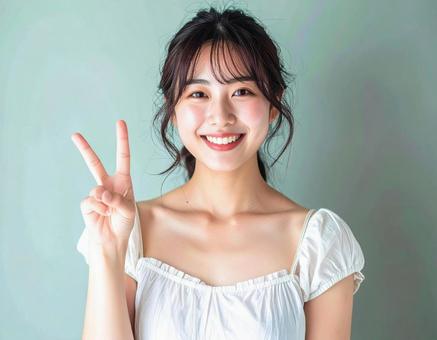 ピースサインをする笑顔の女性 ピースサインをする笑顔の女性の写真