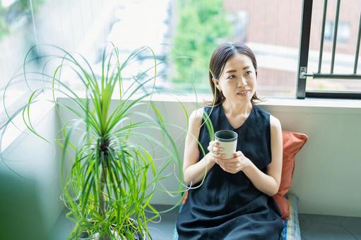 観葉植物に囲まれてリラックスする女性  くつろぐ,ライフスタイル,生活の写真素材
