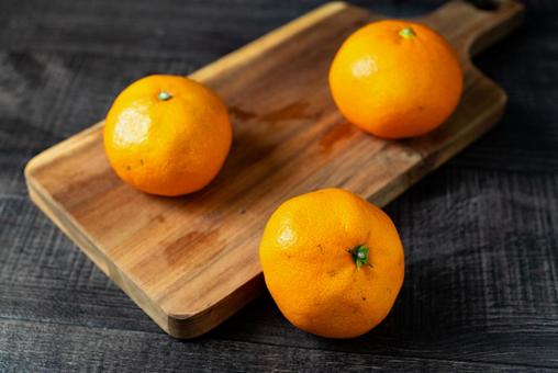 ランダムに置かれたミカン みかん,果物,カッティングボードの写真素材