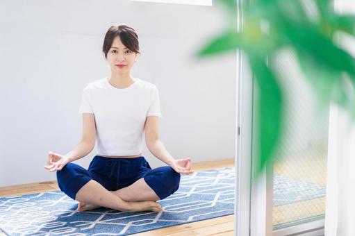 おうちでヨガをする若い女性 おうちでヨガをする若い女性の写真