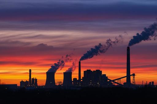 夕焼け空と煙を上げる発電所の風景 夕焼け空と煙を上げる発電所の風景の写真