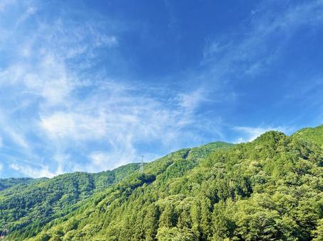 緑あふれる山と穏やかな空模様 緑あふれる山と穏やかな空模様の写真