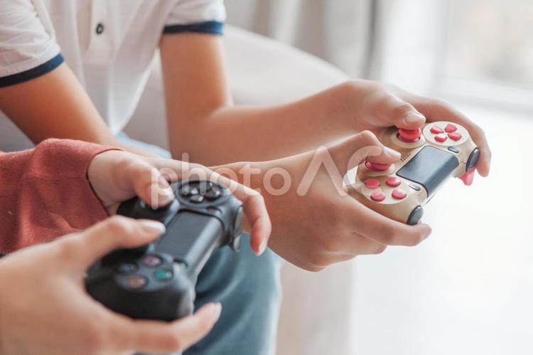 姉弟でゲームをする人の手元 手元,人物,コントローラーの写真素材