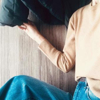 ダウンジャケットを着ようとする女性 ニット,セーター,女性の写真素材