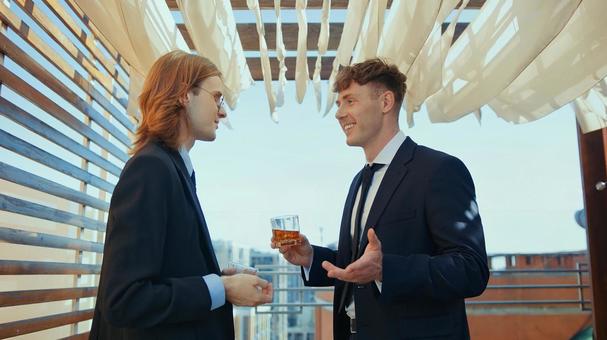 ウイスキーグラスを持ち笑顔で話している男性 男性,外国人,笑顔の写真素材