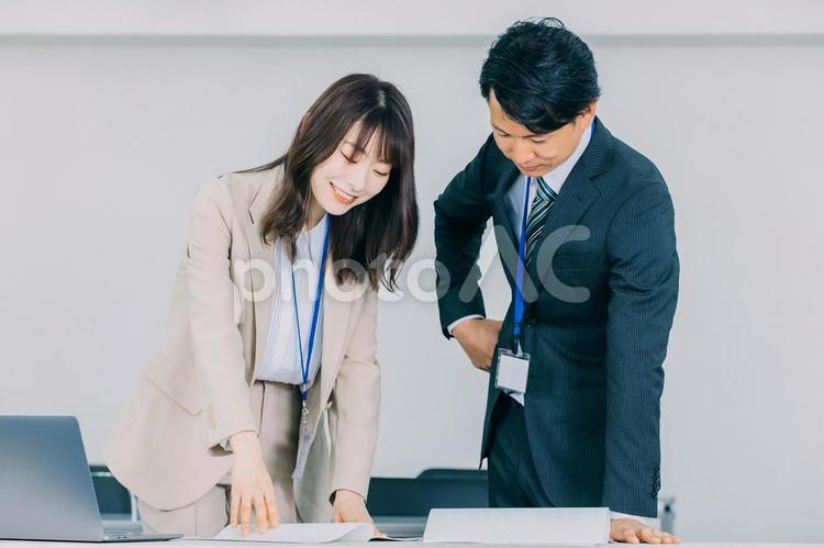 資料を見ながら話す男女のビジネスマン 男性,女性,ビジネスの写真素材