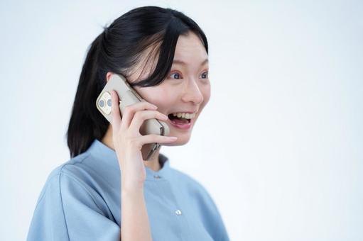 女性がスマートフォンを耳に当てて微笑む 女性,スマートフォン,持つの写真素材