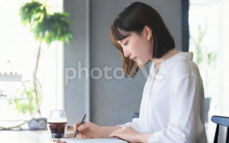 デスクワークをする女性・ビジネスウーマン 女性,デスクワーク,手帳の写真素材