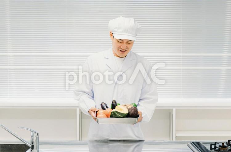 調理服を着た野菜を持つ男性（調理師） 調理師,シェフ,料理人の写真素材