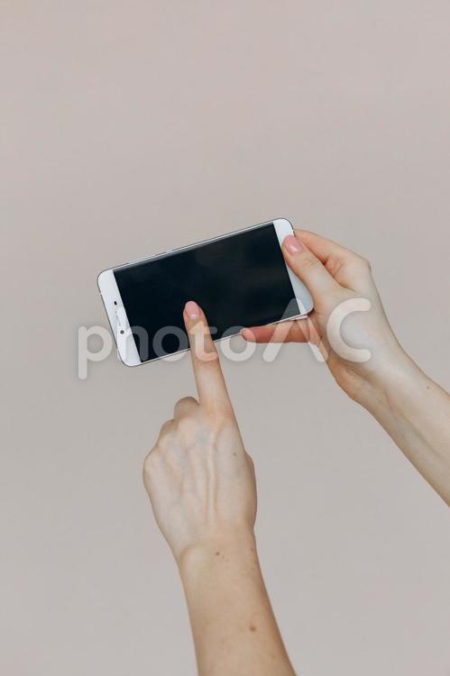 画面を横にして操作する女性 手元,人物,携帯の写真素材