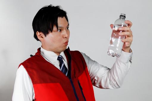 ペットボトルの水を見つめる男性 男性,ペットボトル,水の写真素材