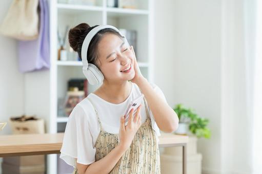 音楽を聴く若い女性 音楽を聴く若い女性 音楽,スマホ,笑顔の写真素材