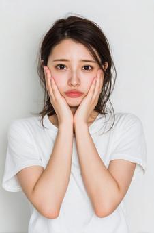 悩みを抱えるような表情の若い日本人女性 悩みを抱えるような表情の若い日本人女性の写真