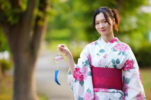 浴衣姿の女性が風鈴を見つめる 女性,浴衣,風鈴の写真素材