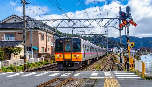 駅の踏切を走る電車 駅の踏切を走る電車の写真
