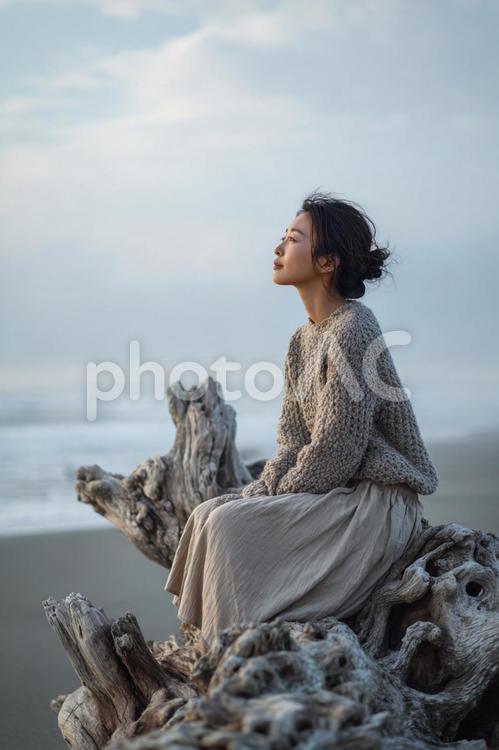 流木の上で、心を澄ますひととき 海,女性,流木の写真素材