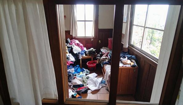 洗濯ものが散乱している女性の狭い部屋 洗濯ものが散乱している女性の狭い部屋の写真