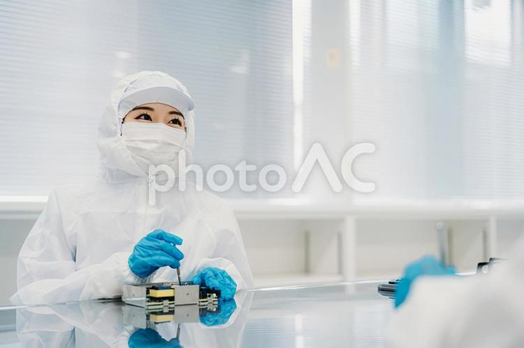 クリーンルームで精密機器を扱う女性 工場,製造業,精密機器の写真素材
