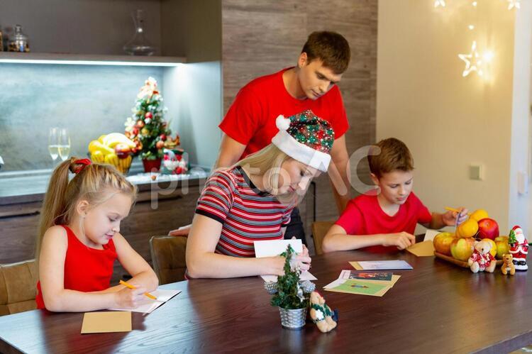 クリスマスカードを書く家族 アフターコロナ,クリスマス,クリスマスカードの写真素材