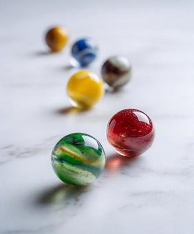 白い床に並ぶビー玉の写真