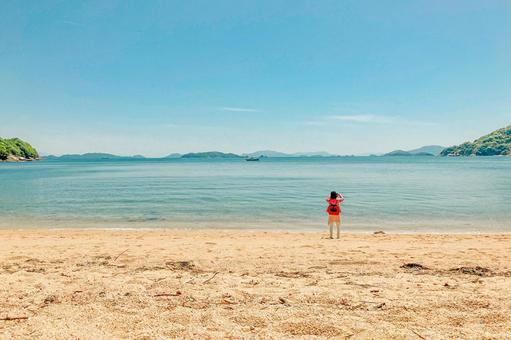 海の写真を撮る女性の写真