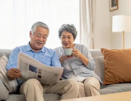 リビングでくつろぐ老後の老夫婦の写真