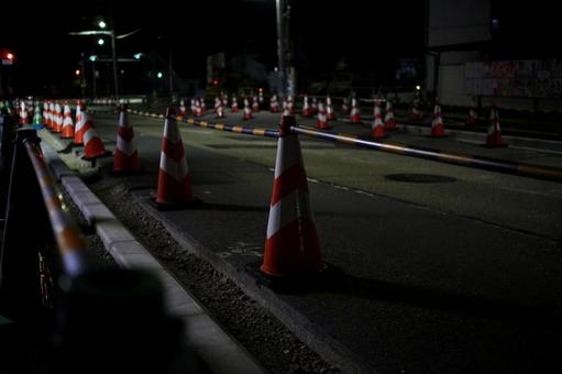 夜の工事現場で並ぶ交通整理のカラーコーン 夜の工事現場で並ぶ交通整理のカラーコーン 道路工事,工事現場,夜間工事の写真素材