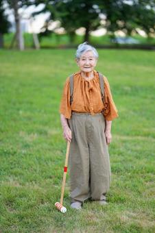 芝生でスティックを待ち立つおばあちゃん 女性,スティック,持つの写真素材