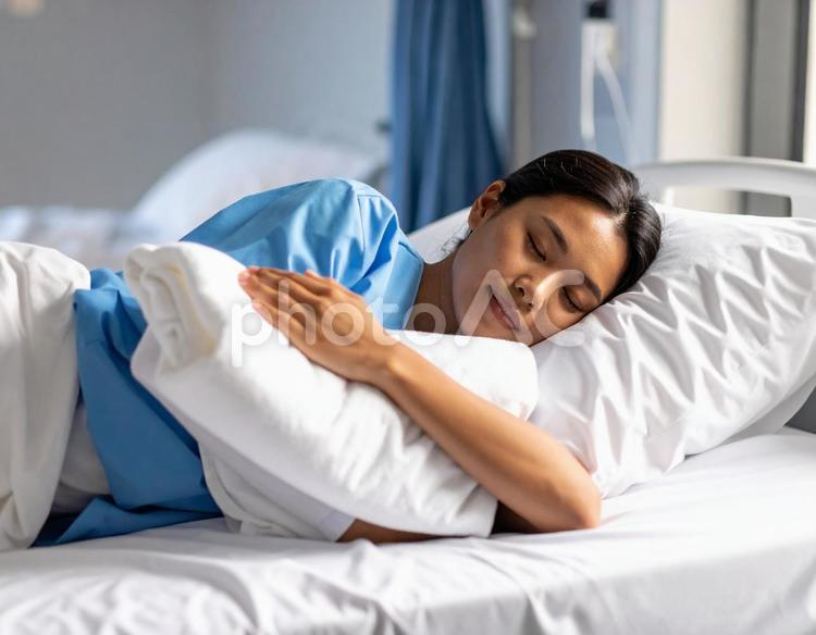 片腕の下にバスタオルを置いて眠る女性患者 バスタオル枕,首こり,背中の写真素材