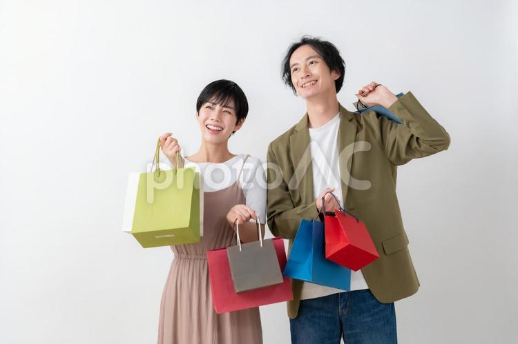 白バックの若い夫婦 ショッピング,カップル,買い物の写真素材