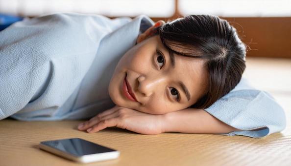のんびりと横になる女性とスマホ のんびりと横になる女性とスマホの写真