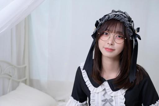 ベッドに腰掛けるメガネの地雷系女子 ベッドに腰掛けるメガネの地雷系女子 カメラ目線,眼鏡,メガネの写真素材