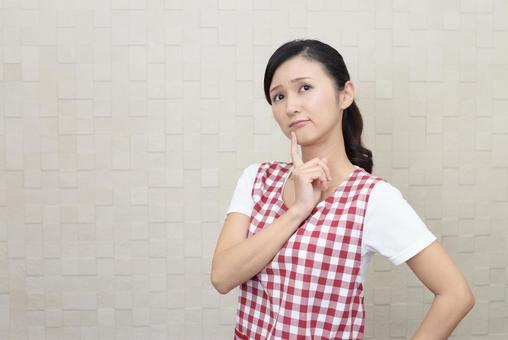 考えるエプロン姿の女性 考えるエプロン姿の女性 女性,考える,疑問の写真素材